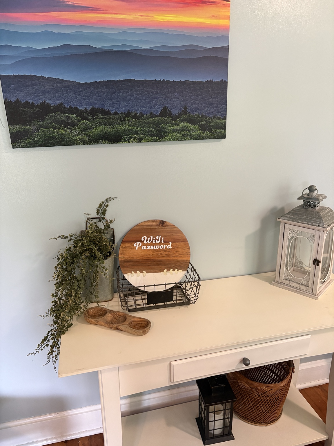 Styled guest console with greenery, lanterns, and a handmade Wi-Fi sign